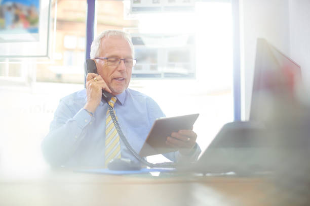 istock Businessman talking to client on the phone in is office 827091728