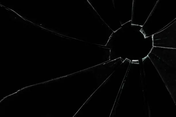 Crackled and broken glass against a black background