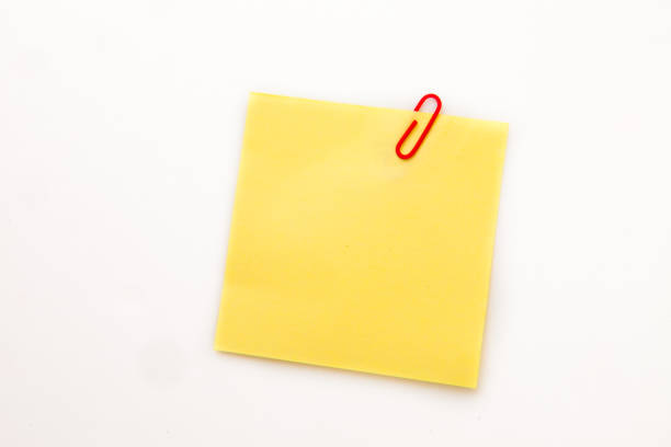 istock Yellow adhesive note with a paperclip 827102078