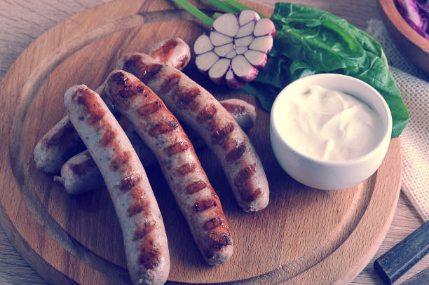 istock grilled bratwurst sausages with sauce, spinach and garlic 827106502