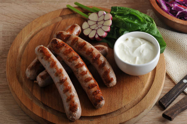 istock grilled bratwurst sausages with sauce, spinach and garlic 827106528