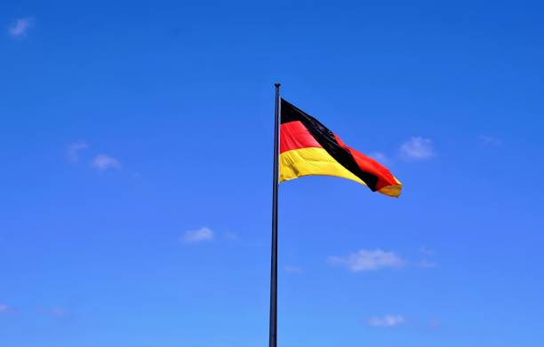istock German flag in front of blue sky 827109390