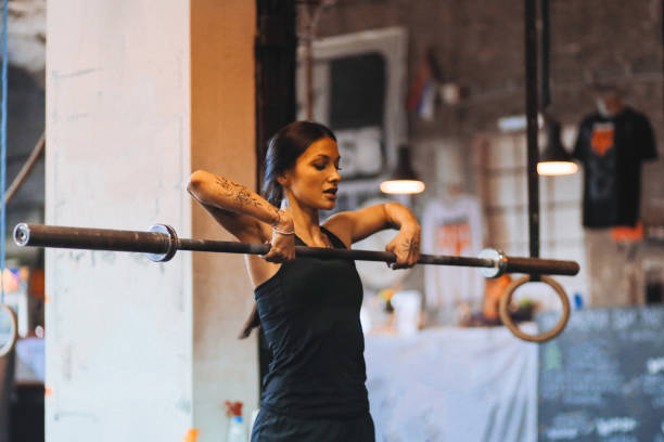 istock Young woman lifting weights on cross training 827112584