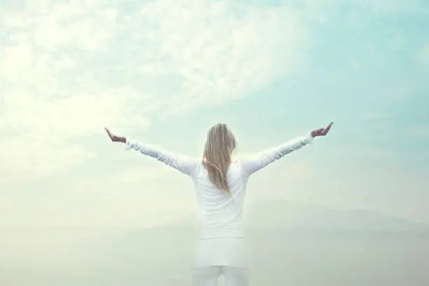 Photo of woman taking a breath in front of a blue sky