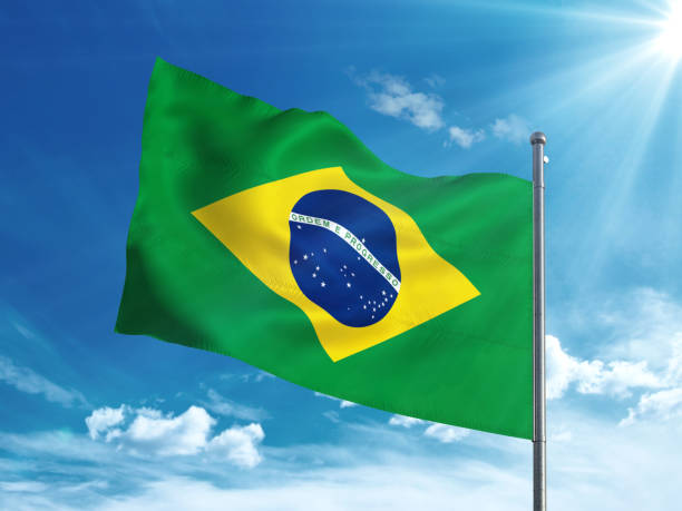 istock Brazil flag waving in the blue sky 827116494