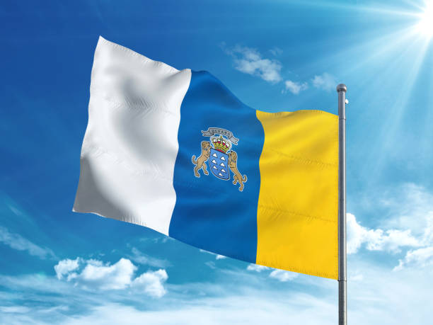 istock Canary Islands flag waving in the blue sky 827116496