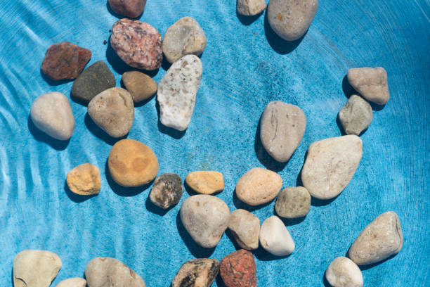 istock pebble stones in water 827118578