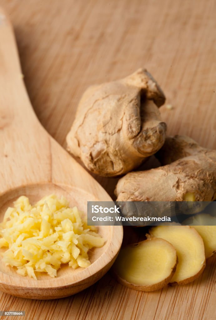 Close up of different forms of ginger Close up of different forms of ginger against a wood worktop Beige Stock Photo