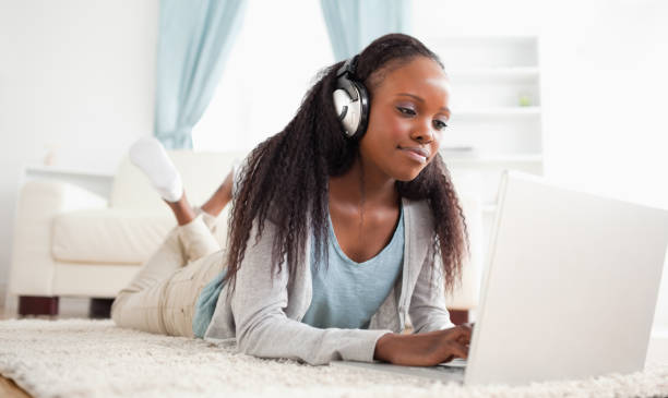 istock Woman lying on the floor with her notebook enjoying music 827143896