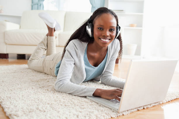istock Woman lying on floor with notebook enjoying music 827144668