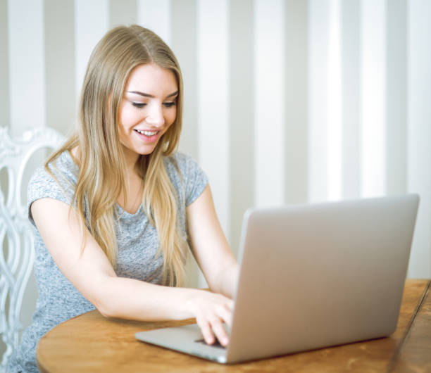 istock Beautiful young woman working with laptop 827144850