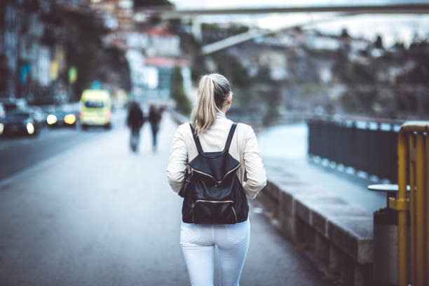 istock Young woman with backpack walking on the european streets 827144904