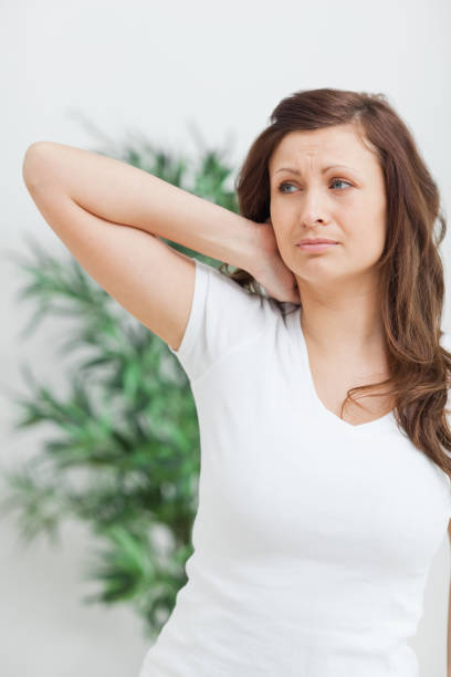 istock Woman standing while placing her hand on her neck 827151824