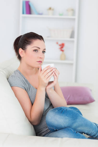 istock Thoughtful woman sitting on the couch 827155086