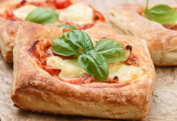 istock Open pies puff pastry with tomato, mozzarella, onion and Basil. Mini pizza. Selective focus 827157598