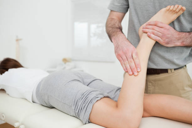 istock Woman lying while a doctor is examining her leg 827161860