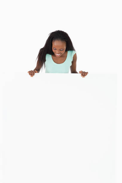 istock Woman looking at placeholder in her hands on white background 827167074