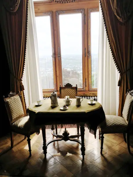Photo of The classical table chair and tableware for breakfast in a old castle style house