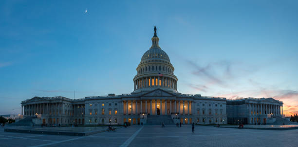 istock Panoramic View of the US Capitol with Moon on the Sky 827173500