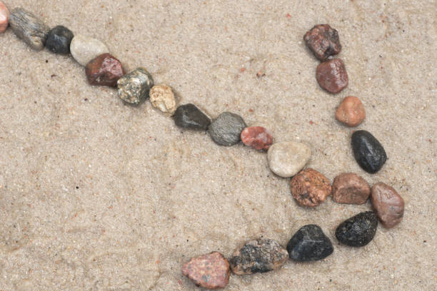 istock pebble arrow sign on sand 827177414