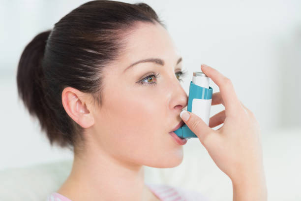 istock Woman using an asthma inhaler 827180372