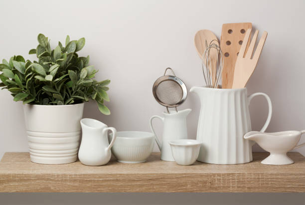 istock Kitchen utensils and dishware on wooden shelf. 827181160