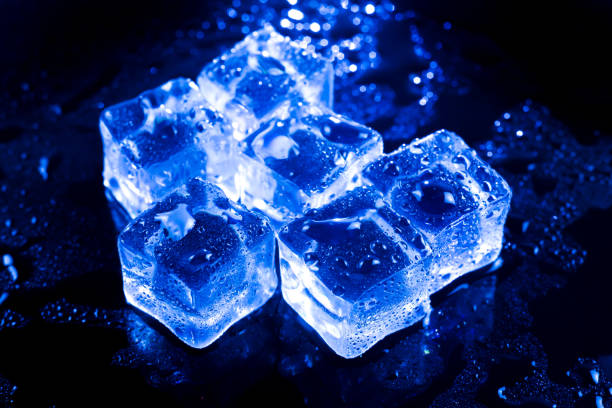 istock Blue ice cubes on black wet table. 827187226