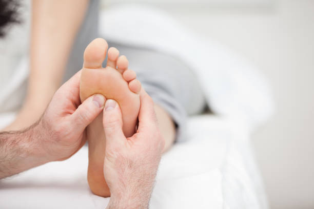 Foot being massaged on a medical table Foot being massaged on a medical table in a room reflexology photos stock pictures, royalty-free photos & images