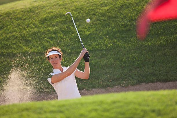 woman golfer hitting out of bunker or sand trap. - golf women female concentration 뉴스 사진 이미지