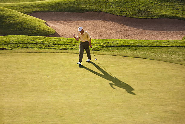 golfer celebrating making putt - baseball cap cap hat golf hat ストックフォトと画像