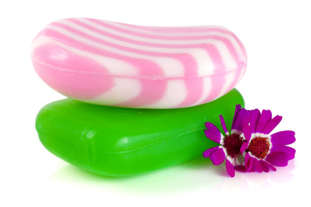 istock Two multi-colored striped soaps with a flower isolated on white background 827208606