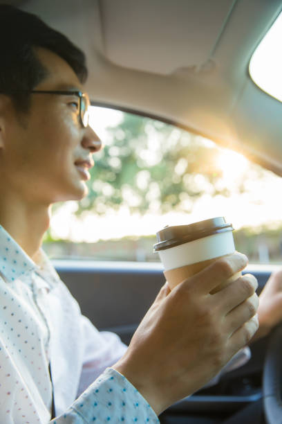 istock Man holding coffee in car 827216118