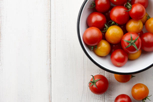 istock Red and yellow cherry tomatoes on white wooden table 827218570