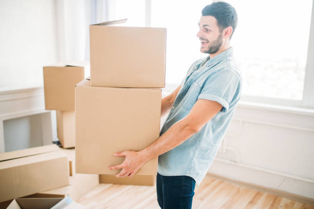 istock Man holds carton box in hands, housewarming 827218712