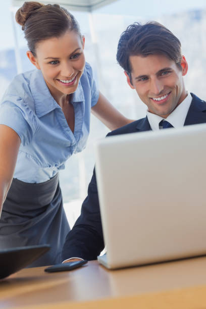istock Business people looking the laptop and smiling 827223328