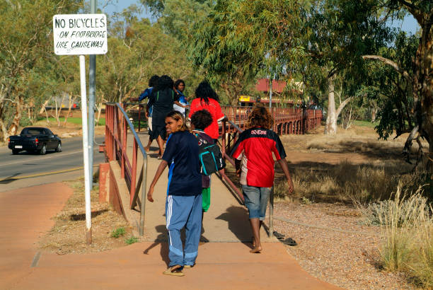 Australia, Aborigines Alice Springs, Australia - February 29th 2008: Unidentified aborigines youth on way to school crossing bridge over dry Todd river alice springs photos stock pictures, royalty-free photos & images