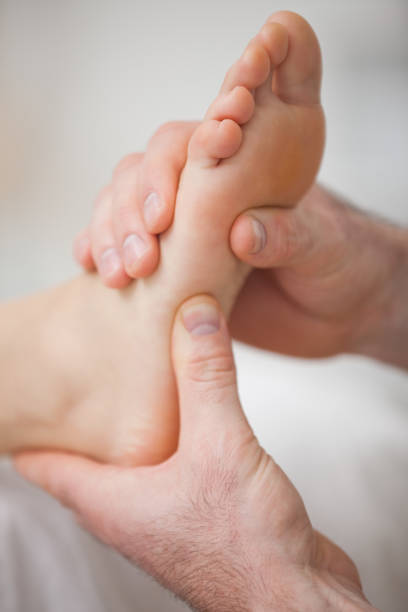 istock Close up of two hands massaging a foot 827227220