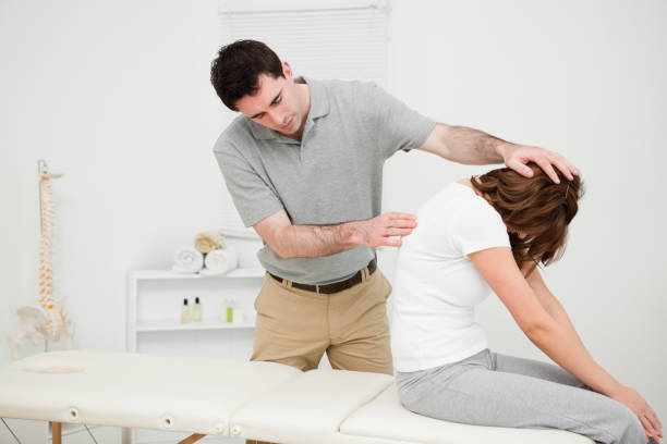 istock Physiotherapist looking at the spinal column of a woman 827227362