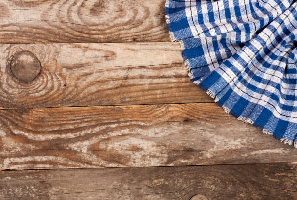 istock blue checkered tablecloth on the old wooden table with copy space for your text. Top view 827227762
