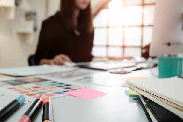 istock Selective focus on creative table and woman graphic design blur in background with vintage tone. 827235176