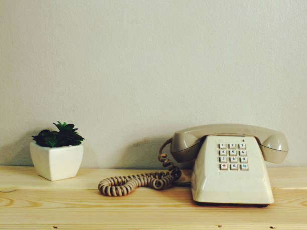 istock retro telephone on wood table wall background 827235376
