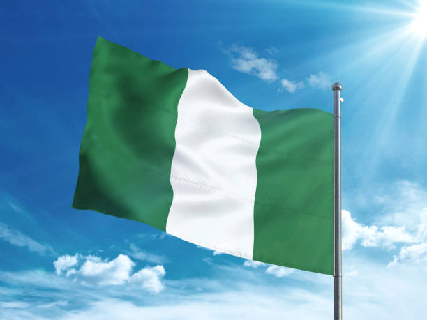 istock Nigeria flag waving in the blue sky 827242078