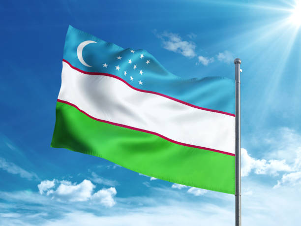 istock Uzbekistan flag waving in the blue sky 827242386