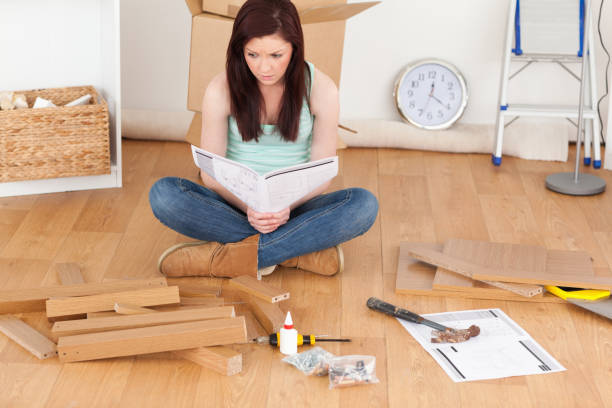 istock Good looking redhaired girl reading a manual before do-it-yourself 827243476