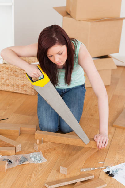 istock Beautiful redhaired woman using a saw 827243618