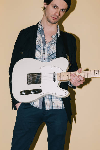 istock Male hipster posing with electric guitar closeup 827247024