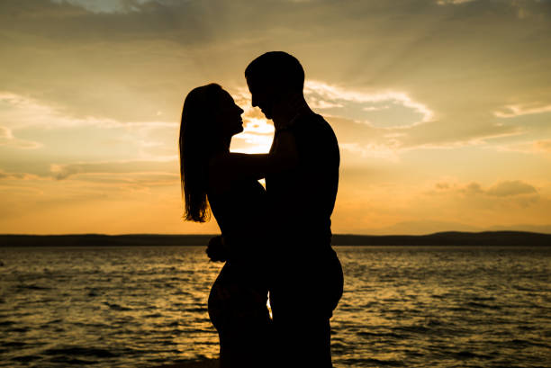 istock Couple silhouette at the beach. Beatiful sunset 827258480