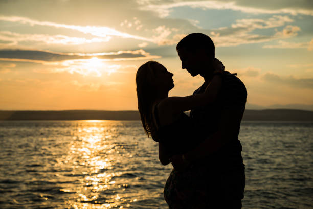 istock Couple silhouette at the beach. Beatiful sunset 827258488