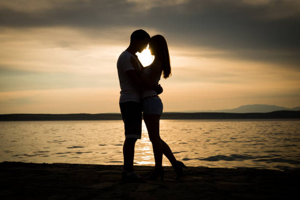 istock Couple silhouette at the beach. Beatiful sunset 827258496