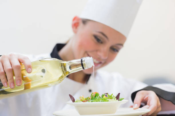 istock Smiling woman chef dressing a salad 827261960